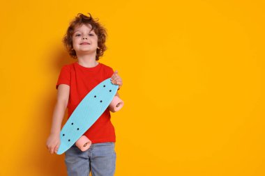 Turuncu arka planda bozuk para tahtası olan şirin küçük çocuk, mesaj için yer var.