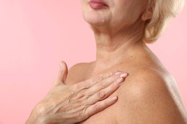 Açık pembe arka planda güzel bir son sınıf güzeli, yakın plan. Metin için boşluk