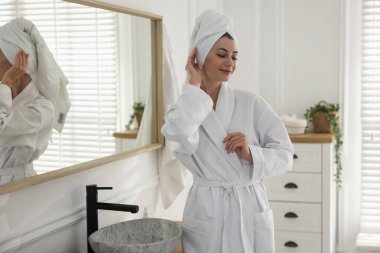 Bornoz ve havlu giymiş güzel bir kadın.