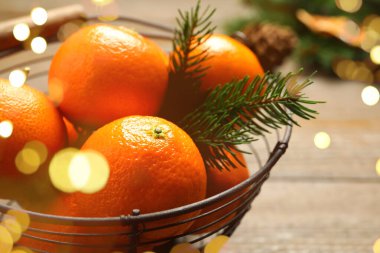 Taze mandalinalar ve tabakta köknar dalları.