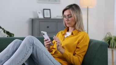 Kadın içeride telefon ve kredi kartıyla çevrimiçi ödeme yapıyor.