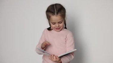 Sevimli küçük kız beyaz arka plan üzerinde kitap okuma