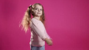 At kuyruklu şirin küçük kız pembe arka planda eğleniyor.