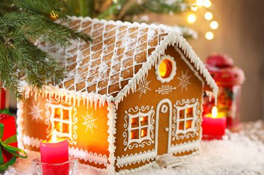 Güzel zencefilli kurabiye evi ve Noel dekoru masada, yakın plan.