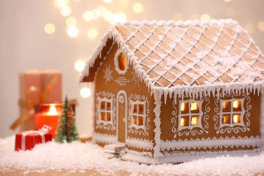 Güzel zencefilli kurabiye evi ve Noel dekoru bulanık ışıklara karşı, yakın plan