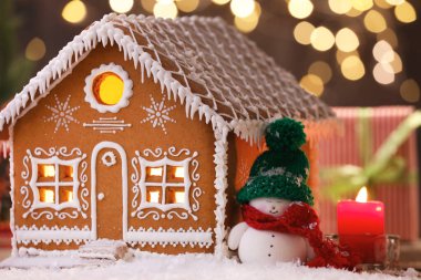 Güzel zencefilli kurabiye evi ve Noel dekoru bulanık ışıklara karşı, yakın plan