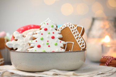 Lezzetli zencefilli kurabiye ve Noel ışıklarına karşı masada mum yakmak, yakın plan. Bokeh etkisi