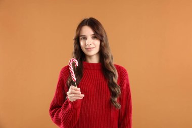 Bej arka planda şeker kamışlı güzel bir kadının portresi. Mutlu Noeller ve mutlu yıllar.