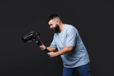 Siyah zemin üzerinde kamera olan titreşimli dengeleyici kullanan kameraman