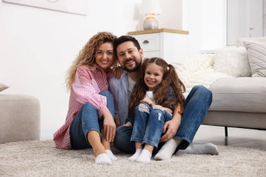 Mutlu aile evde yerde sarılıyor.