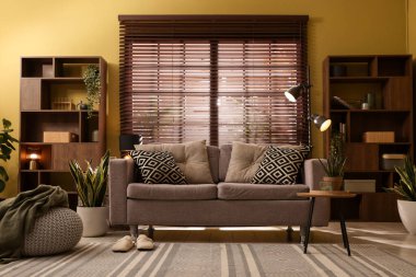 Oturma odasının içi rahat kanepe, diğer mobilyalar ve dekorlarla dolu.