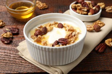 Ahşap masada sunulan bal ve fındıklı lezzetli Yunan yoğurdu, yakın plan.