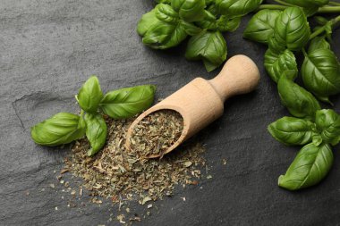 Siyah desenli masa üzerinde taze ve kuru fesleğen yaprakları.