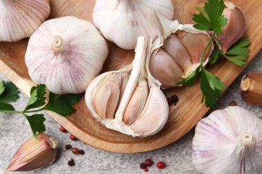 Garlic, peppercorns and parsley on light table, closeup