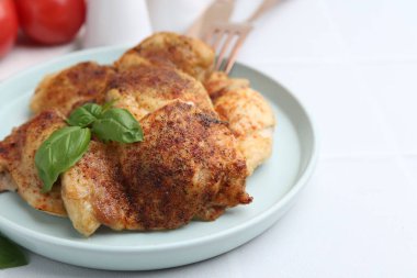 Lezzetli kavrulmuş tavuk butları ve fesleğenli beyaz fayanslı masa, yakın çekim. Metin için boşluk