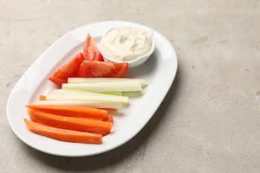 Açık gri masada farklı taze sebzeler ve sos, yakın plan. Metin için boşluk