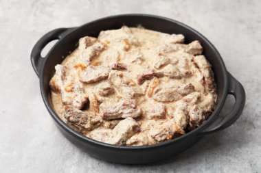 Lezzetli Stroganoff bifteği gri masada, yakın plan.