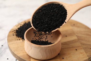 Beyaz mermer masadaki kaseye aromatik siyah oyma dökülüyor, yakın plan.