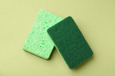 Açık yeşil arka planda mutfak süngerleri, üst görünüm