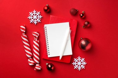 New Year aims. Planners, pen and festive decor on red background, flat lay