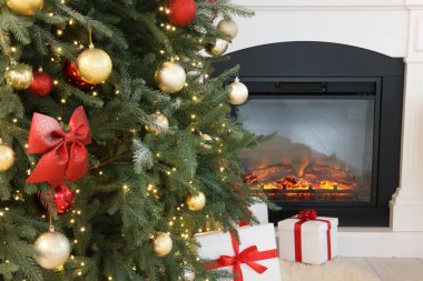 Noel ağacı, şenlikli bir dekor ve şık bir odada şömine. İç tasarım