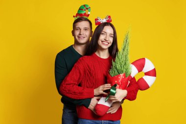 Yılbaşı bantlı, sarı arka planda şeker kamışı olan mutlu çift.