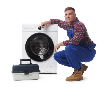 Beyaz arka planda çamaşır makinesi ve alet çantası olan üniformalı bir tamirci.