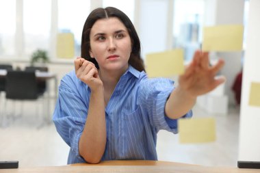 Ofisteki cam tahtaya not yapıştıran kadın, seçici odaklanma