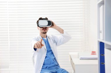 Modern teknoloji. Ofiste sanal ekran kullanan kulaklıklı bir doktor