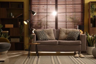 Oturma odasının içi rahat kanepe, diğer mobilyalar ve dekorlarla dolu.