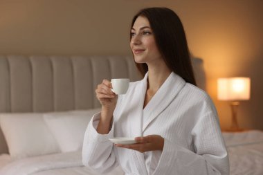 Bornozlu güzel bir kadın ve yatağında sabah kahvesi var. Metin için boşluk