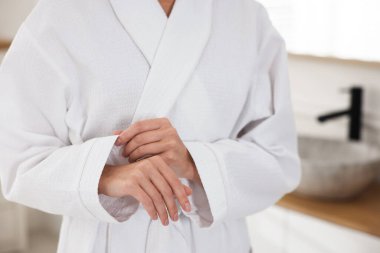 İçerde rahat beyaz bornoz giyen kadın, yakın plan.