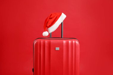 Noel tatili. Kırmızı arka planda Noel Baba şapkası olan çanta.