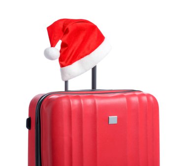 Noel tatili. Beyaz arka planda Noel Baba şapkası olan kırmızı bavul.