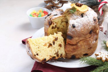 Lezzetli noel panettone pastası pudra şekeri ve beyaz masa üzerinde şenlikli dekor, yakın plan.