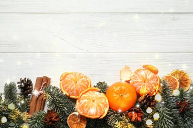 Taze mandalinalar ve köknar dalları beyaz ahşap masa, üst manzara. Bokeh ışıkları