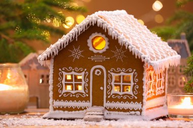 Güzel zencefilli kurabiye evi ve Noel dekoru bulanık ışıklara karşı, yakın plan