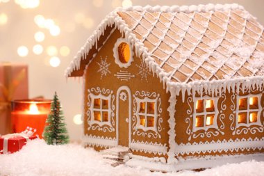 Güzel zencefilli kurabiye evi ve Noel dekoru bulanık ışıklara karşı, yakın plan