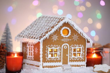 Güzel zencefilli kurabiye evi ve Noel dekoru bulanık ışıklara karşı, yakın plan