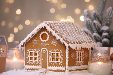 Güzel zencefilli kurabiye evi ve Noel dekoru bulanık ışıklara karşı, yakın plan