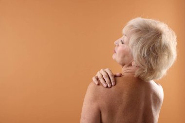 Soluk turuncu arka planda güzel bir son sınıf öğrencisi. Metin için boşluk