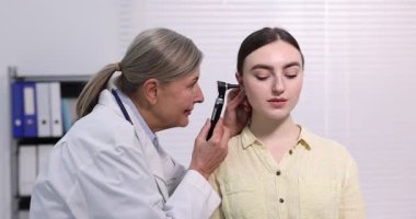 Duyma testi. Klinikte otoskopla hastaları muayene eden doktor..