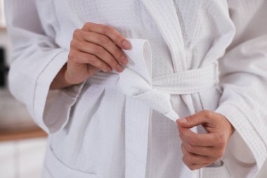 Bornozun kemerini bağlayan kadın, yakın plan.