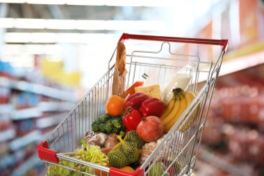 Süpermarketteki ürünlerle dolu alışveriş arabası.