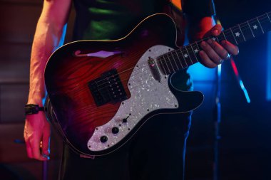 Sahnede elektro gitarlı bir adam, yakın plan.