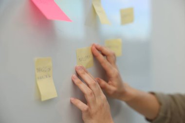 Ofisteki beyaz tahtaya kelimelerle yatırım yapan kadın kapatıyor.