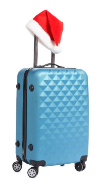 Noel tatili. Beyaz arka planda Noel Baba şapkası olan mavi bavul