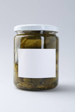 Hafif arka planda kavanozda salatalık turşusu, yakın plan.