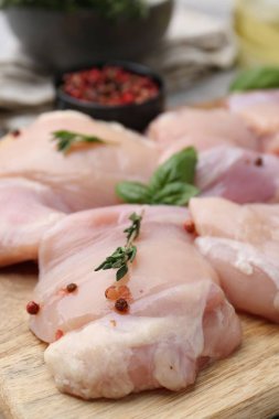 Çiğ tavuk butları, bitkiler ve karabiber, yakın plan.