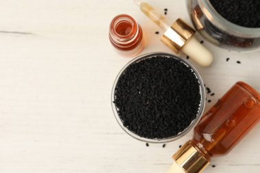 Siyah kimyon tohumları ve gerekli yağ şişeleri açık ahşap masa üzerinde, düz yatıyordu. Metin için boşluk